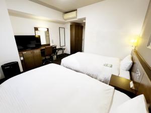 由利本荘市にあるホテルルートイン由利本荘のベッド2台とテレビがあるホテルの部屋