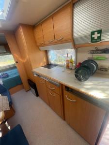 a kitchen in an rv with wooden cabinets and a sink at TerraOliva&herbs in Vátos
