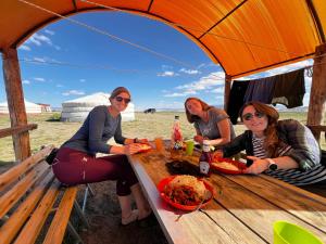 three women sitting at a table in a tent at City guesthouse & tours in Ulaanbaatar