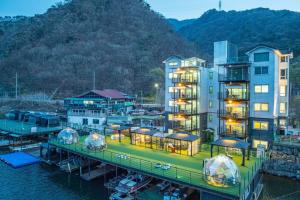 a building with a dock next to the water at Gapyeong Petite Dog Pension in Ch'ŏngp'yŏng