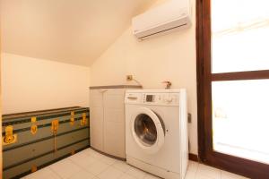 a laundry room with a washing machine and a window at Villa Acquario in Torre delle Stelle