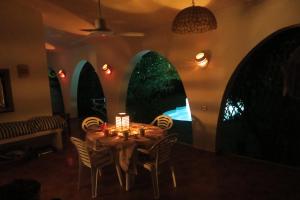 a dining room with a table with chairs and a candle at Villa Acquario in Torre delle Stelle