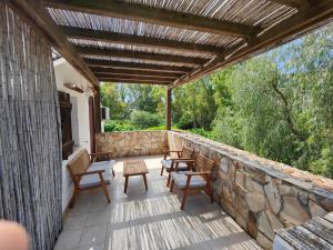 a patio with chairs and a stone wall at Villa Acquario in Torre delle Stelle