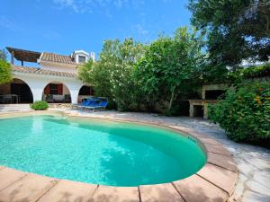 a swimming pool in front of a house at Villa Acquario in Torre delle Stelle