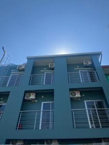 a blue building with air conditioners in the windows at TKH The Bed in Ban Khlong Bang Krathiam
