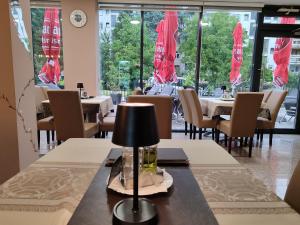 ein Esszimmer mit Tischen, Stühlen und Fenstern in der Unterkunft Malena in Goražde