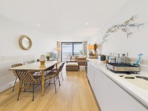 a kitchen and living room with a table and chairs at Luxury 3-bed apartment, with direct beach access, free parking & sea views ! in Falmouth +32 photos