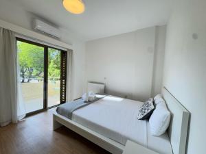 Un dormitorio blanco con una cama y una ventana grande. en Wealthystays Stasandrou Residence, en Nicosia