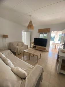 a living room with a couch and a tv at Terreta de Denia in Denia