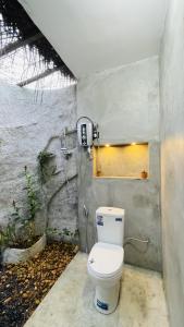 a bathroom with a toilet and a window at The wilds Sinharaja in Deniyaya +38 photos