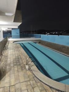 a swimming pool on top of a building at night at Apartamento Cabo Frio RJ in Cabo Frio