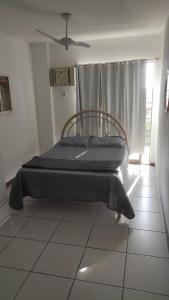 a bed sitting in a room with a window at Apartamento Cabo Frio RJ in Cabo Frio +14 photos