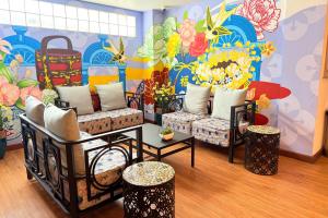 a room with couches and a mural of flowers at Days Inn by Wyndham Patong Beach in Patong Beach