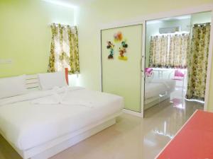 une chambre avec un lit blanc et un miroir dans l'établissement Holland Resort Phuket, à Ban Phlu Yai