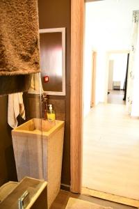a bathroom with a sink and a mirror and a hallway at Maison de Chacha in Hammamet