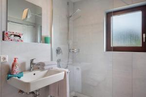 ein weißes Badezimmer mit Waschbecken und Dusche in der Unterkunft Ferienwohnung Rieslehof Nr9 in Titisee + 32 Fotos