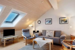 ein Wohnzimmer mit Sofa und Fernseher in der Unterkunft Ferienwohnung Rieslehof Nr9 in Titisee