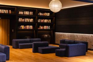 a waiting room with blue chairs and bookshelves at Hotel Gracery Shinjuku in Tokyo