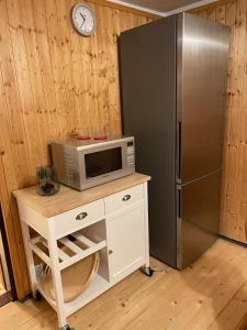 eine Mikrowelle auf einem Tisch neben einem Kühlschrank in der Unterkunft Spirkenhütte Fichtelberg - Ferienhaus bis 6 Personen - mit Sauna - am Fichtelsee in Fichtelberg