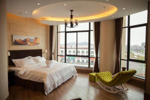 a bedroom with a bed and a chair and windows at Jinjiang Metropolo Hotel - Liyang Tianmu Lake in Liyang +239 photos