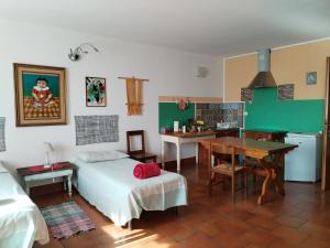 a bedroom with a bed and a table and a kitchen at Stasion Di Pueste in Nogaredo