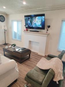 a living room with a fireplace with a flat screen tv at sofi intuit cozy home free parking queen beds in Inglewood