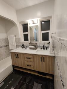 a bathroom with a sink and a tub and a mirror at sofi intuit cozy home free parking queen beds in Inglewood