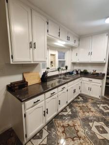 a kitchen with white cabinets and a sink at sofi intuit cozy home free parking queen beds in Inglewood