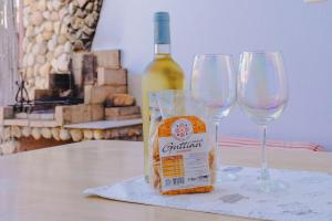 a bottle of wine and two wine glasses on a table at Casa Costa degli Angeli in Santa Luria +8 photos