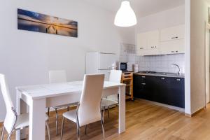 a kitchen and dining room with a white table and chairs at Casa Costa degli Angeli in Santa Luria