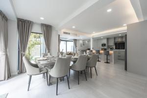 een eetkamer en keuken met een tafel en stoelen bij V192 Brand New Golf side 5BR Villa with Private Pool in Ban Kathu (1)