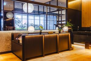 a lobby with a reception desk and large windows at Hotel Gracery Shinjuku in Tokyo