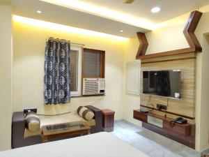 a living room with a tv and a couch at Hotel Shree Radhe & Banquet in Darbhanga