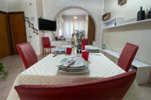a dining room with a table and red chairs at Civico 21 in Càbras