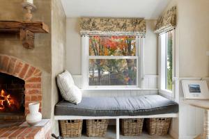 ein Fensterplatz in einem Wohnzimmer mit Kamin in der Unterkunft Collins Cottage - Luxury Accommodation in Bright