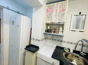 een kleine keuken met een spoelbak en een koelkast bij Piso Salou in Salou