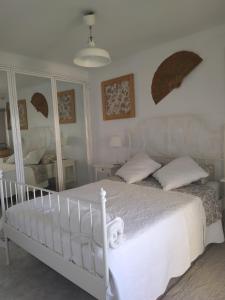 een slaapkamer met een wit bed en een spiegel bij Piso Salou in Salou