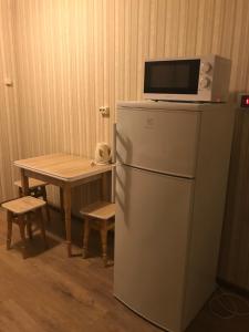 a microwave on top of a refrigerator next to a table at Amio more in Odesa