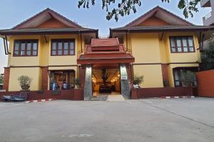 南邦Yellow Tique Hotel的一座大型黄色建筑,有很多窗户