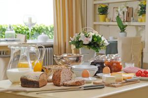 a breakfast table with bread and eggs and cheese at Hotel Les Arcades in Knokke-Heist