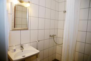 ein Bad mit einem Waschbecken, einem Spiegel und einer Dusche in der Unterkunft Motel Højmølle Kro in Eskilstrup