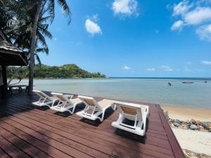 un gruppo di sedie sedute su un ponte sulla spiaggia di Wooden villa in resort with pool, 100m from the beach a Mae Haad