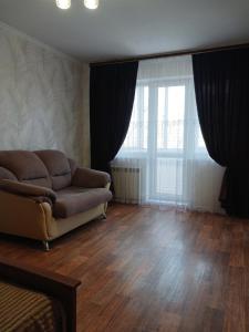 a living room with a couch and a large window at Апартаменты в центре города со смарт тв и Wi-Fi in Karagandy