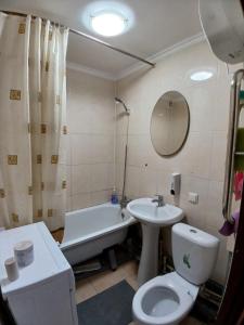 a bathroom with a toilet and a sink and a tub at Апартаменты в центре города со смарт тв и Wi-Fi in Karagandy