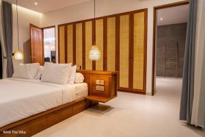 a bedroom with a bed and a large mirror at NAIA The Villa - Modern Tropical Retreat in Canggu +37 photos