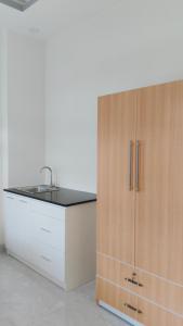 a kitchen with a sink and a wooden cabinet at Amy Hotel & Apartment in Da Thanh