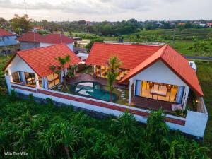a house with a red roof and a swimming pool at NAIA The Villa - Modern Tropical Retreat in Canggu