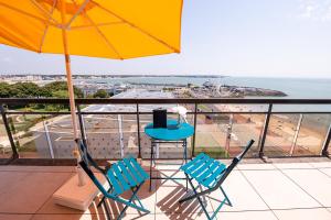 a balcony with two chairs and a table and an umbrella at Best Western Hôtel Royan Océan in Royan