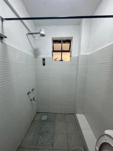 a bathroom with a toilet and a window at Pamoja stays - Modern studio near transit with balcony and workspace in Rungiri