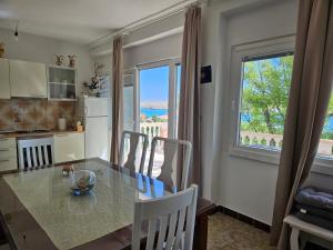 a kitchen with a table with chairs and a window at Apartment Zdenka in Dinjiška
